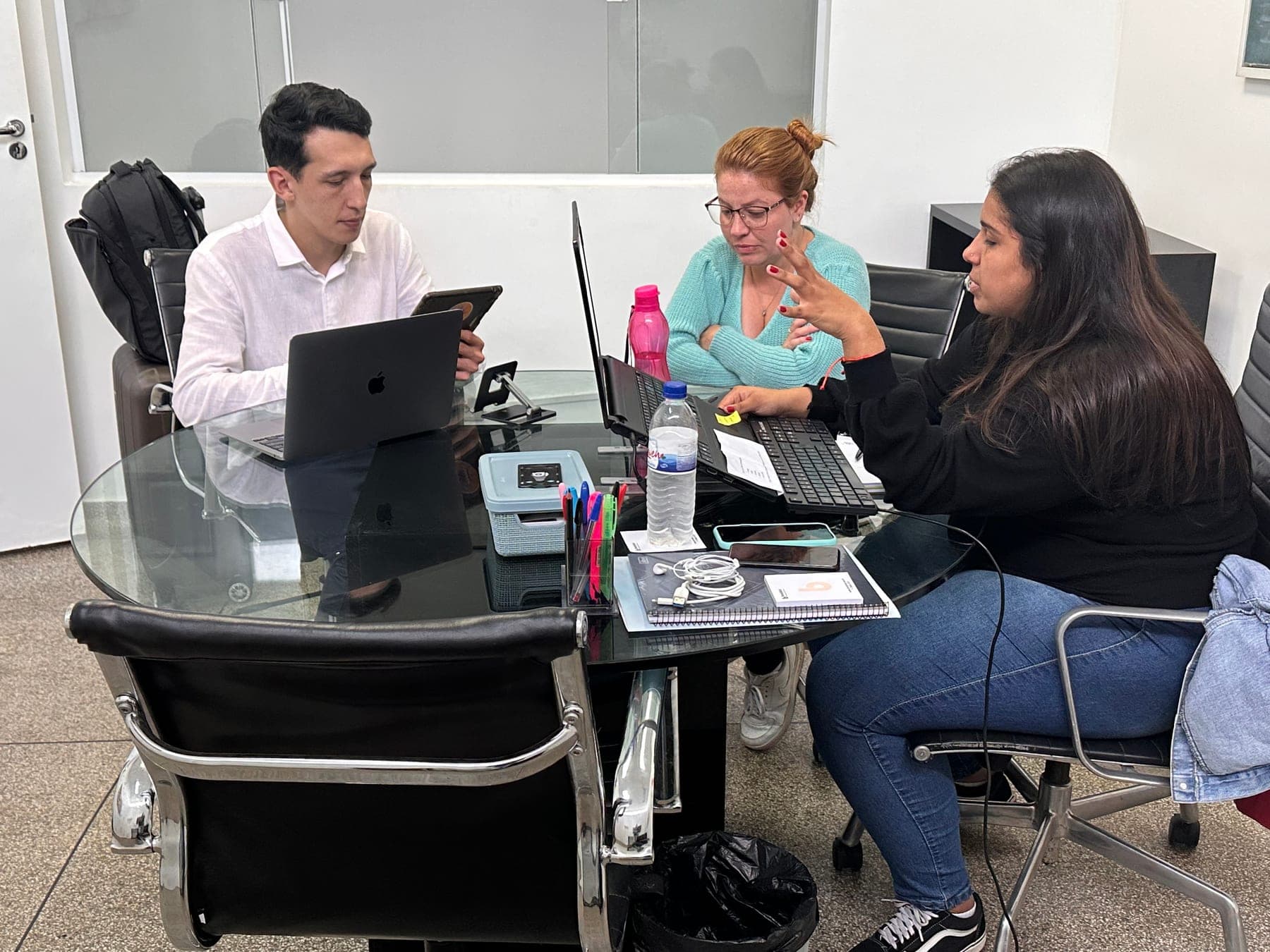 Renan Goulart em sessão de trabalho à mesa com duas pessoas do time de um cliente.